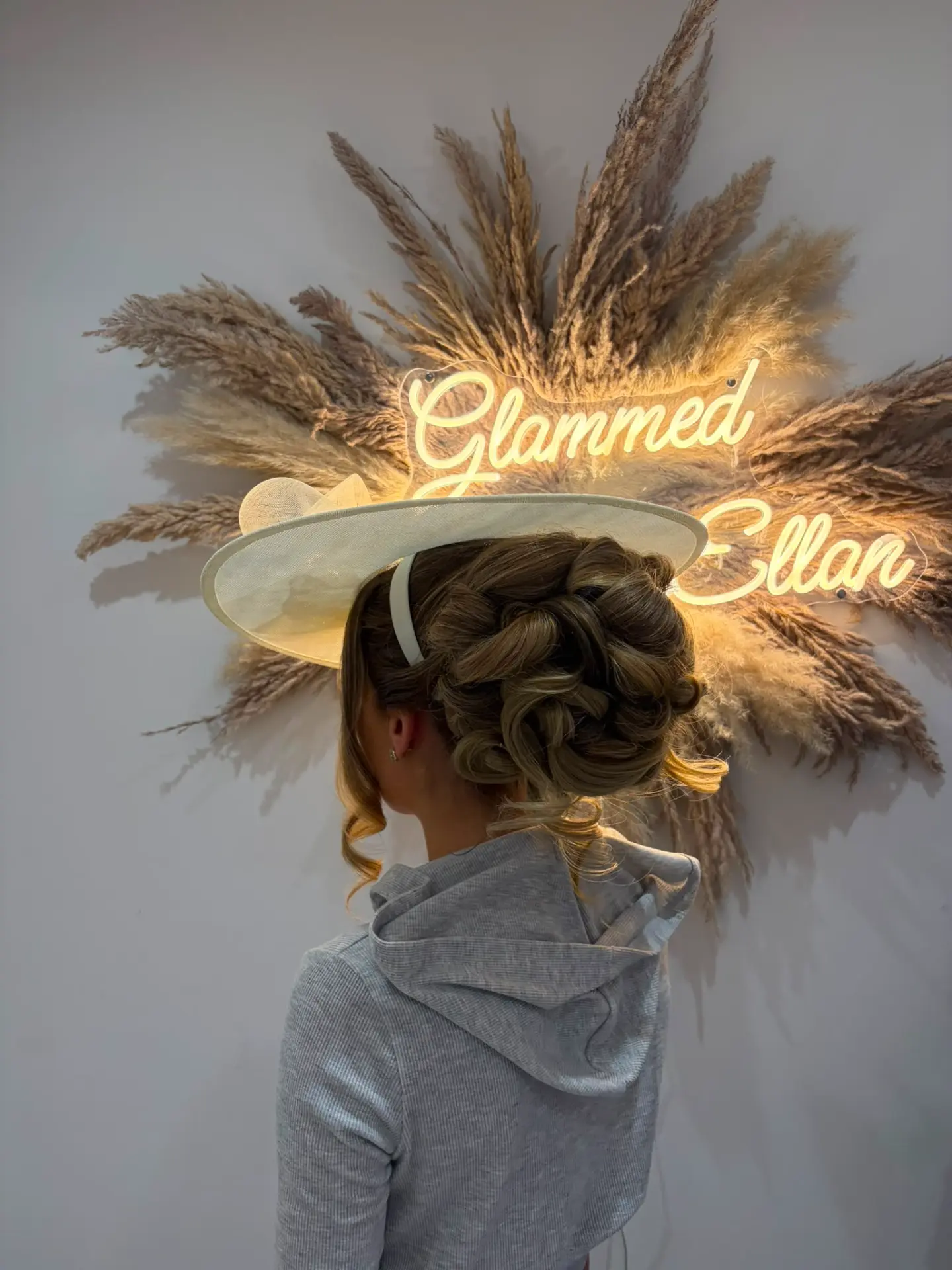 Occasion updo styled around an ivory hat