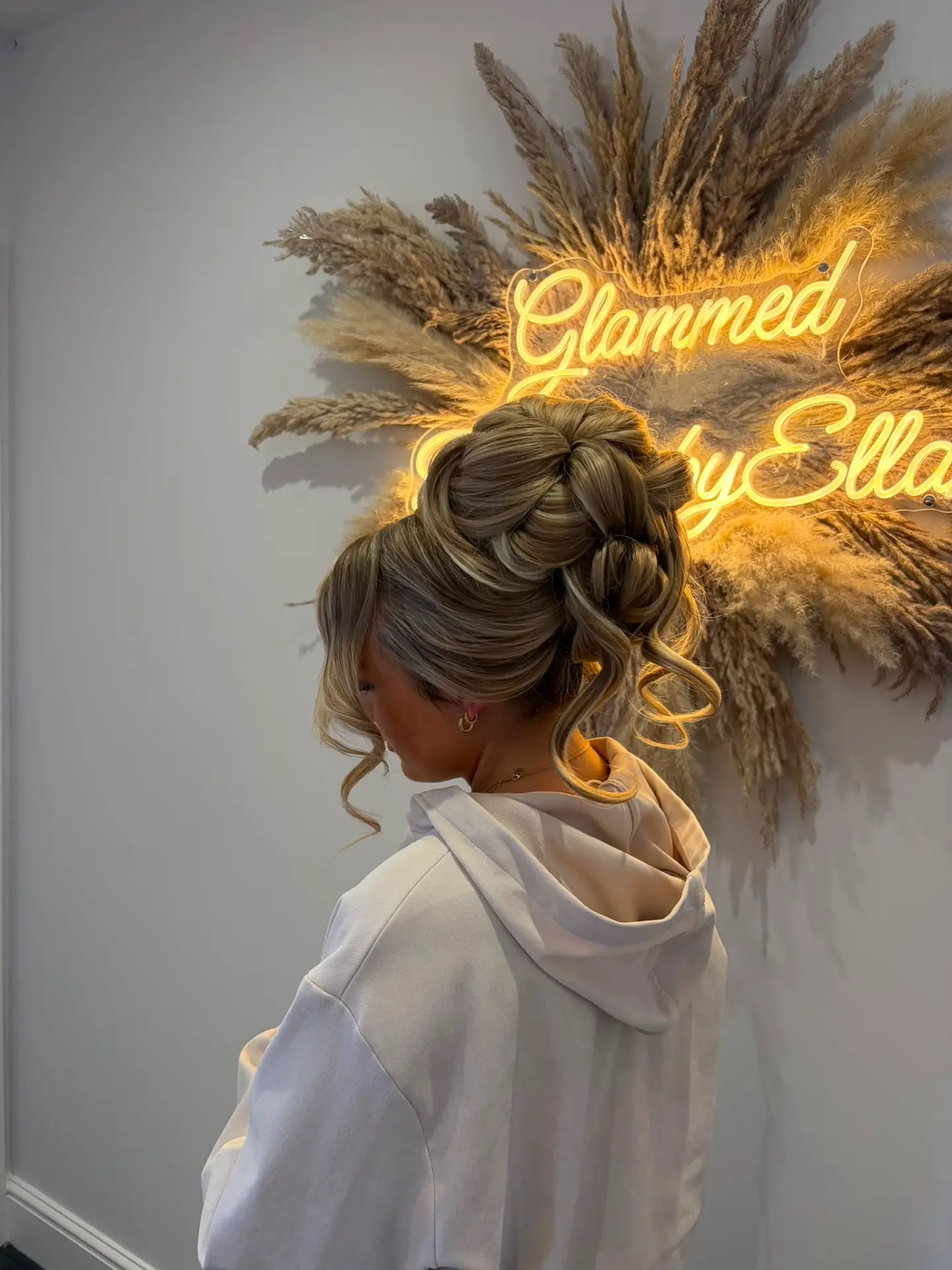 Textured high bun with loose tendrils