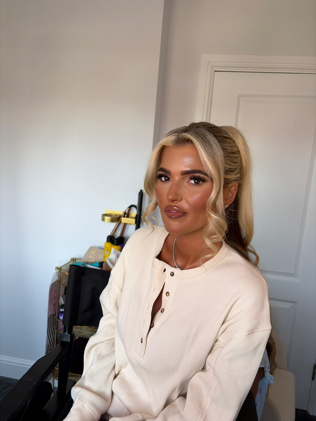 Half-up blonde style with curls and full glam makeup