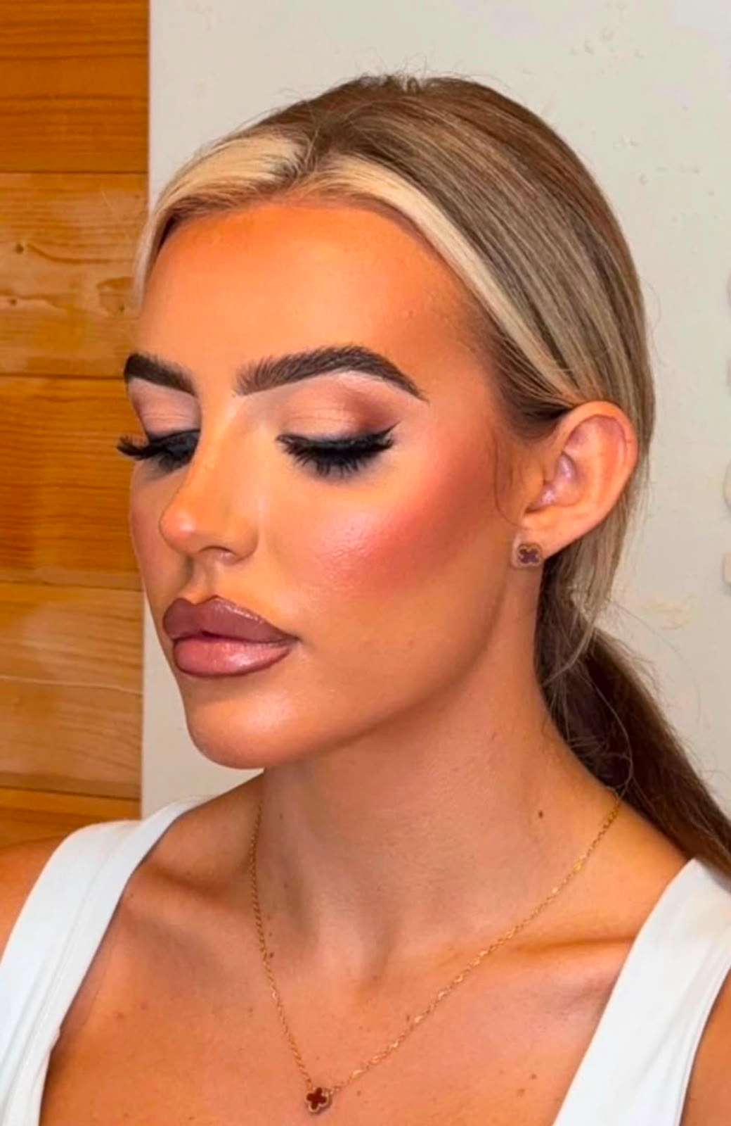 Soft glam makeup with sleek pulled-back hair